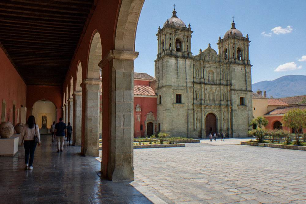 Visitors walking through a gallery of the Museo de las Culturas inside the Santo Domingo complex