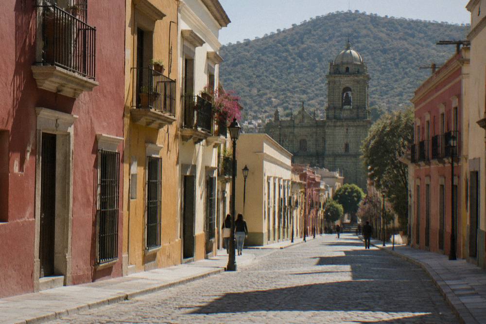 Long morning shadows crossing a cobbled street in Oaxaca's historic centre