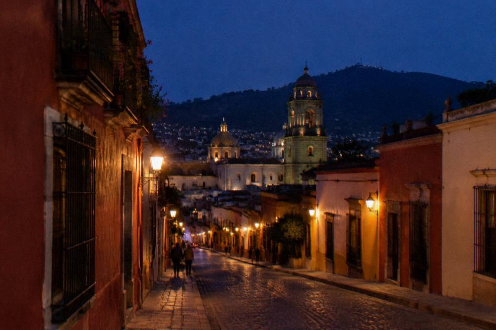 Rooftops and church domes of Oaxaca City seen from high ground at dusk