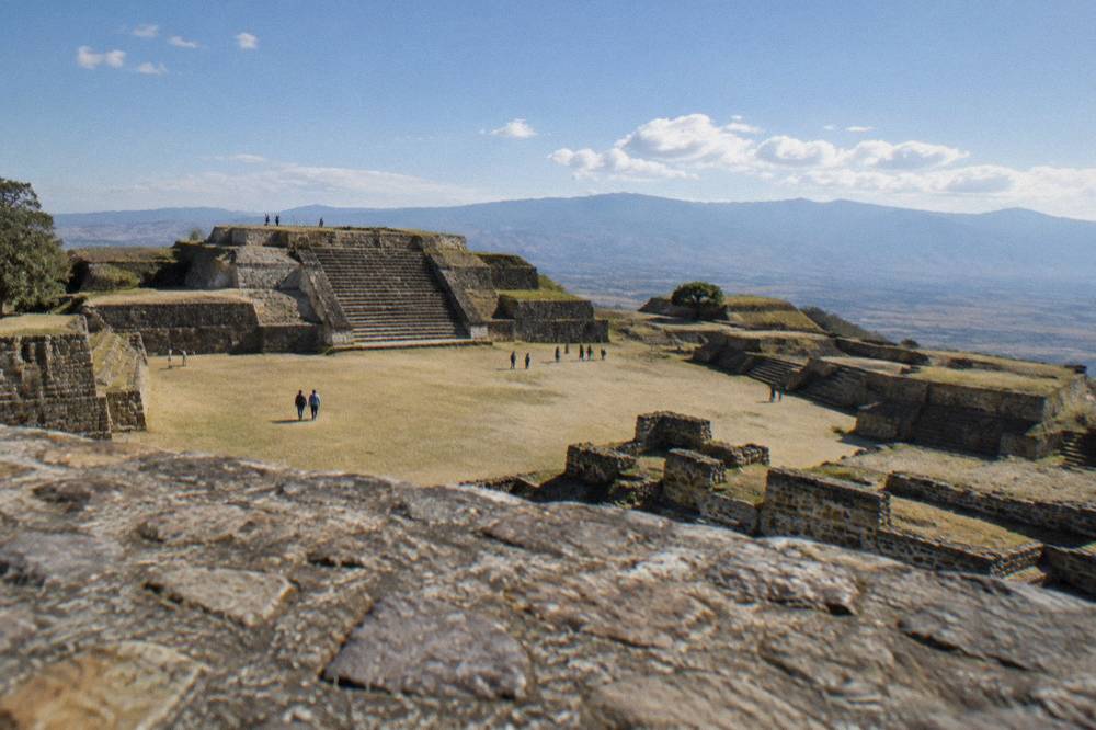 Ancient stone platforms of Monte Albán under open sky in late afternoon