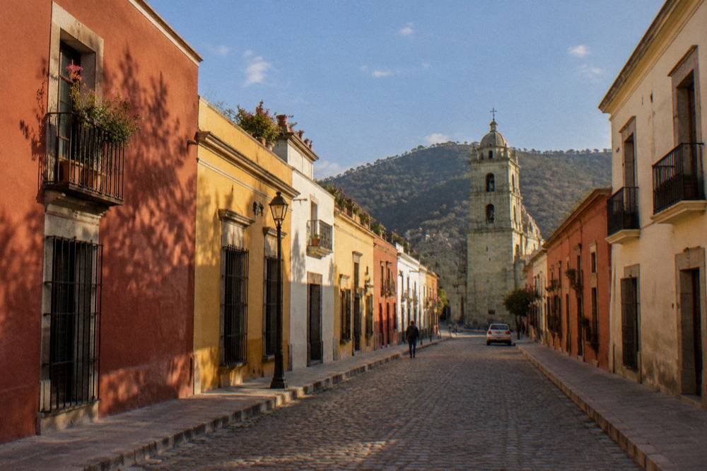 A valley road outside Oaxaca City passing agave plants and low hills