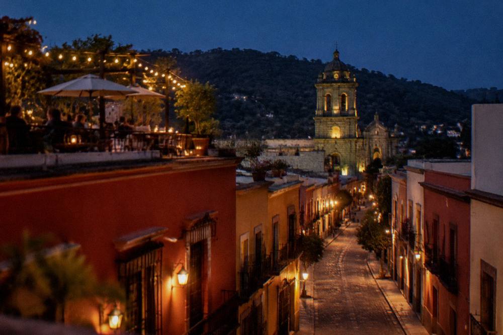 A rooftop terrace with tables and string lights above the streets of Oaxaca City