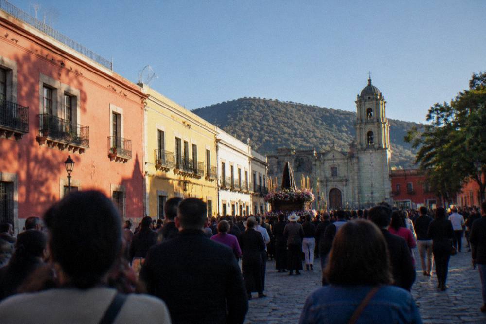 Crowd on a plaza in Oaxaca City during an evening procession with banners and music