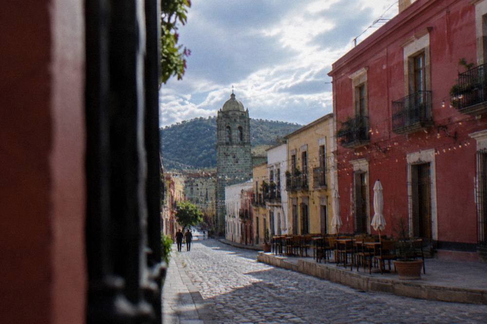 Strings of lights and empty rooftop tables set for an evening service in Oaxaca City