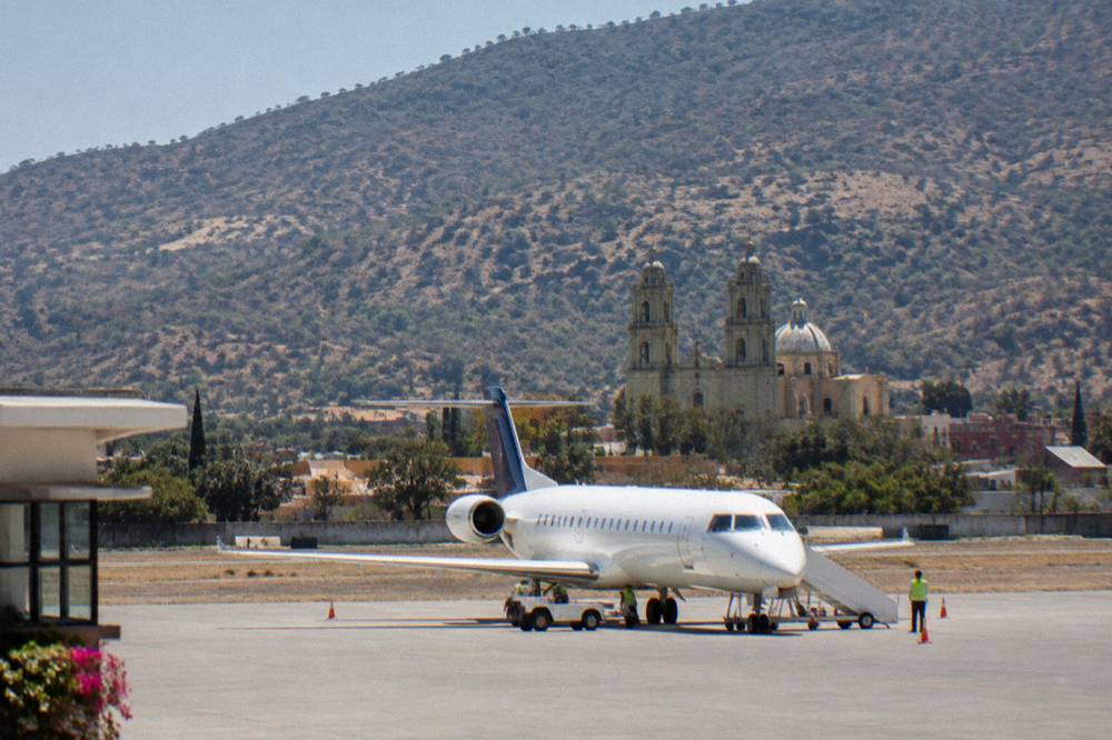 A small airliner on the apron at Xoxocotlán Airport in late afternoon light