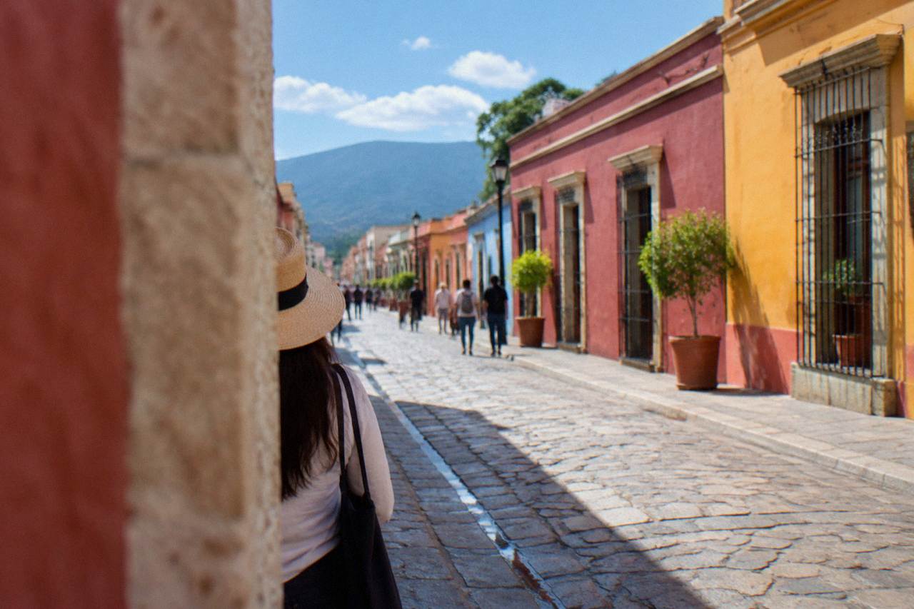 Colourful colonial buildings and a stone street in the historic centre of Oaxaca City under a bright sky