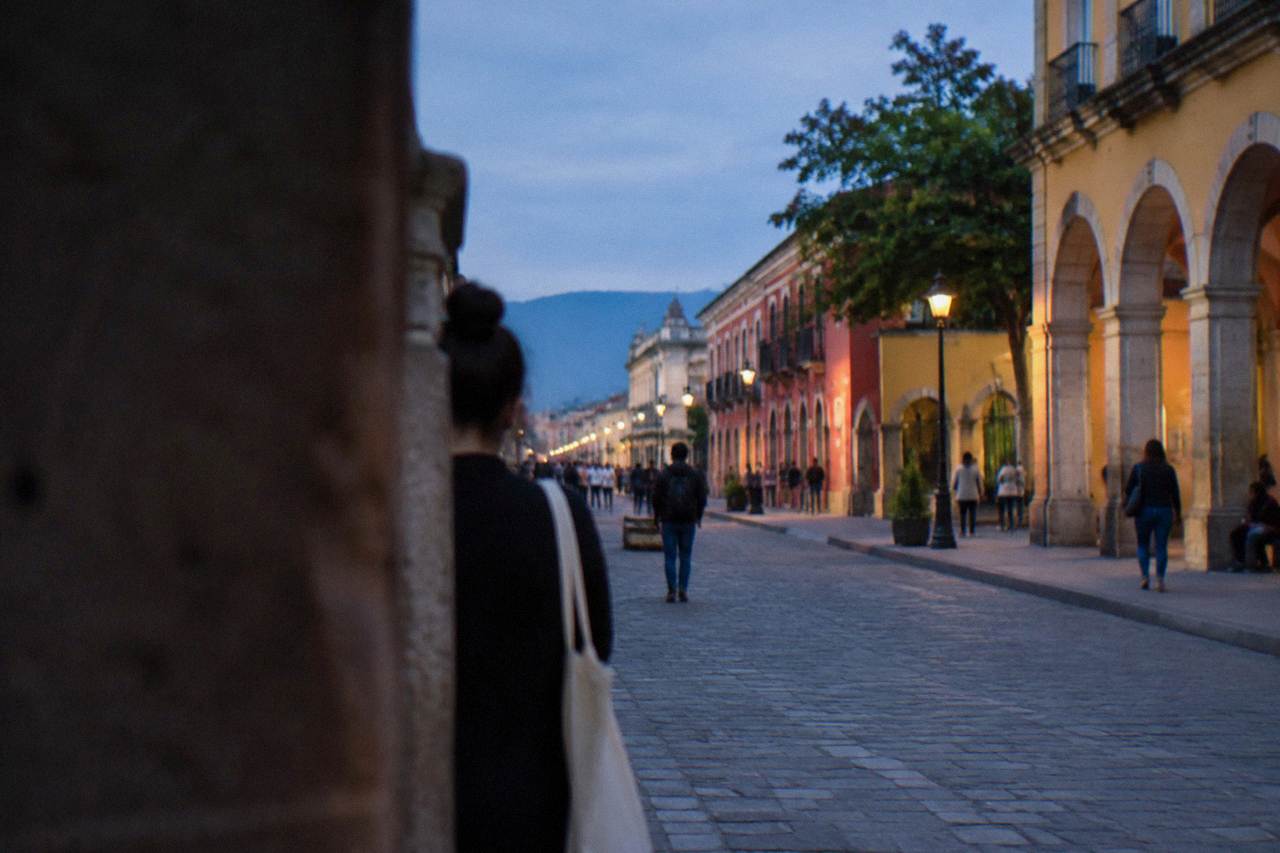A busy Oaxaca street with colonial facades in warm afternoon light