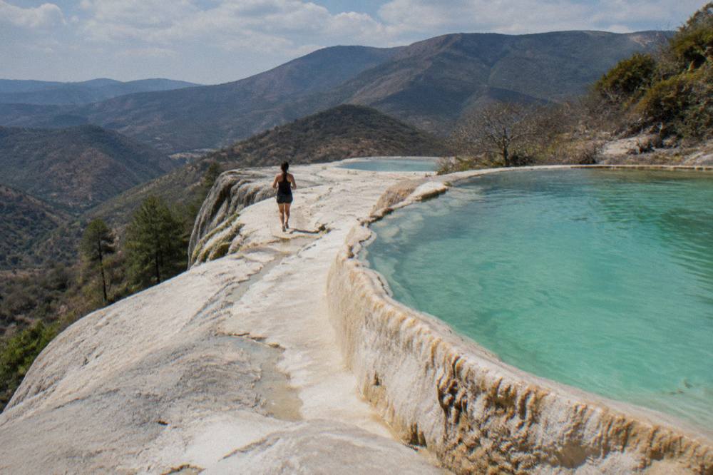 Mineral terraces and turquoise pools at Hierve el Agua with mountains behind