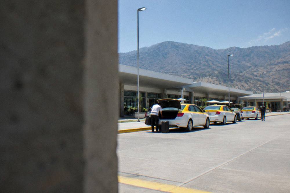 The terminal forecourt of Oaxaca's airport with taxis waiting in daylight