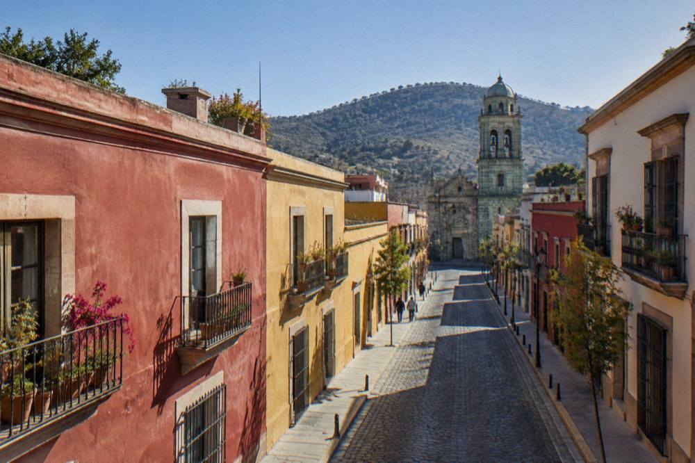 Sunny street in central Oaxaca with coloured facades and clear sky