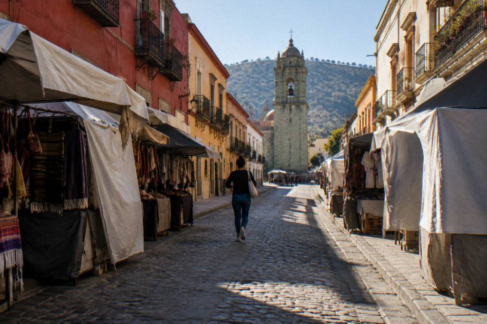 A quiet market lane in Oaxaca City in morning light with covered stalls on both sides