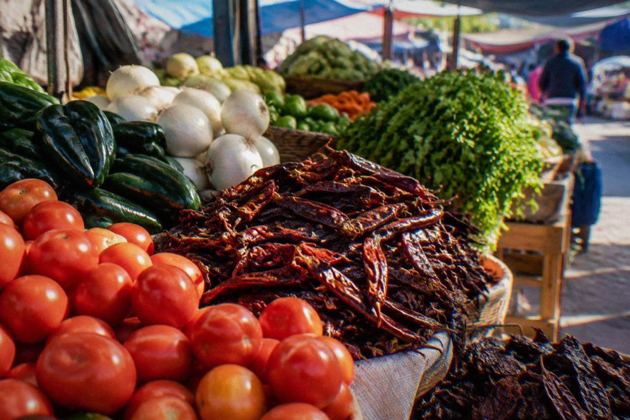 A market stall in Oaxaca piled with fresh vegetables and dried chiles