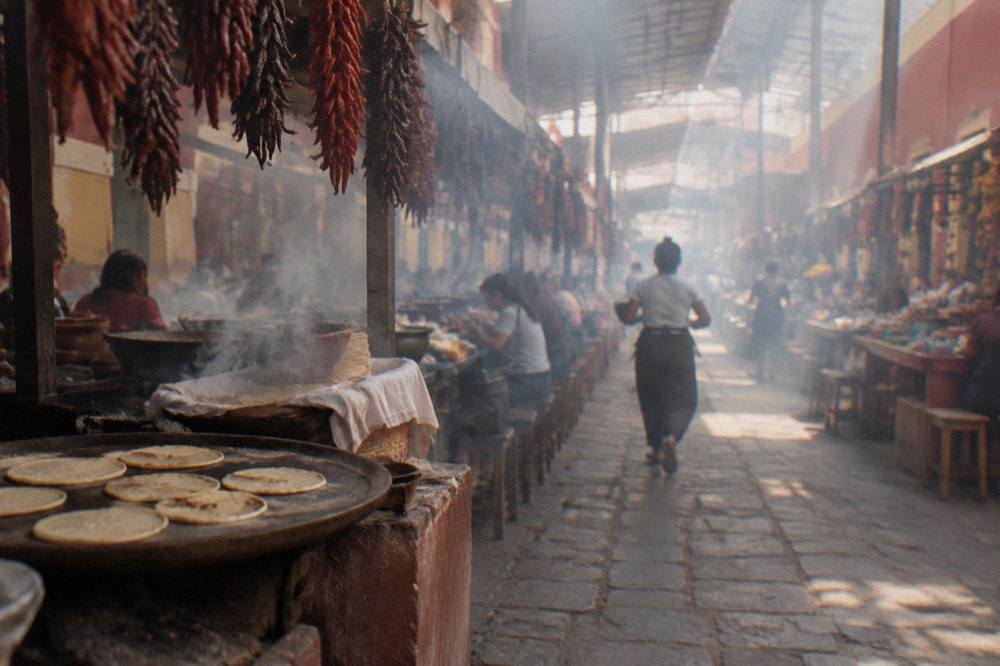 Fresh corn tortillas cooking on a hot clay comal in a market kitchen