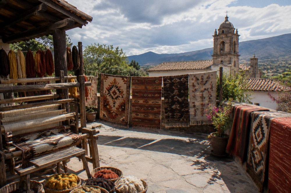 Handwoven wool rugs with natural dyes displayed in a weaving workshop