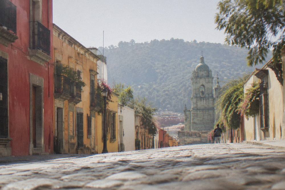 A path climbing a wooded hill above the rooftops of Oaxaca City