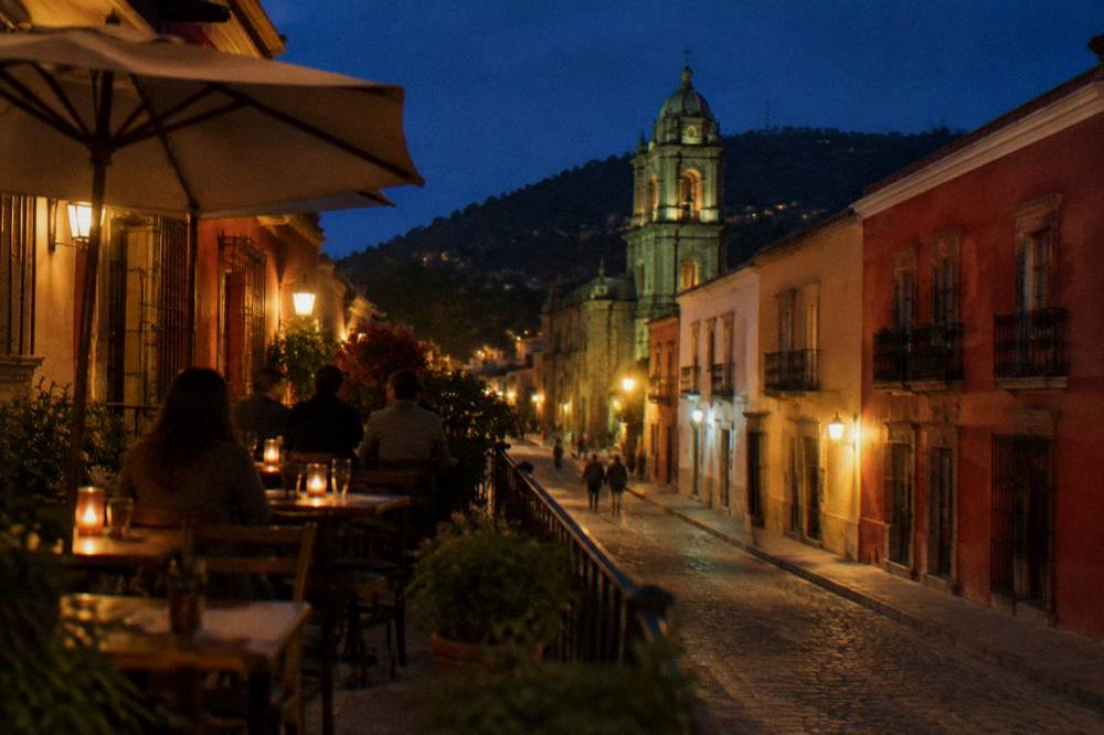 An open-air terrace in Oaxaca City at dusk with people in light jackets at the tables