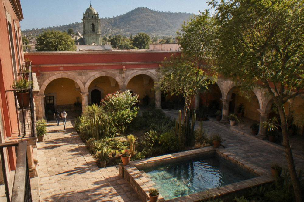 A shaded courtyard garden with cacti and stone arcades in central Oaxaca