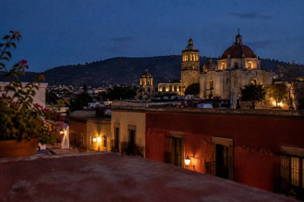 A Oaxaca City rooftop at dusk with the church domes of the historic centre