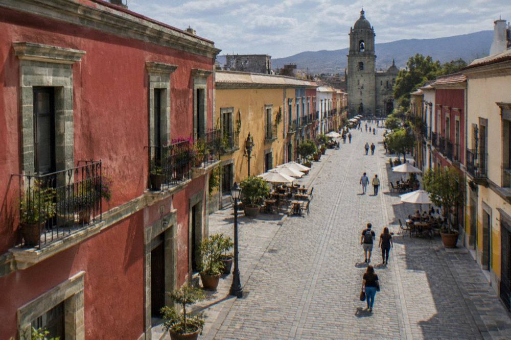 A pedestrian street in the Oaxaca historic centre with green canarian stone buildings