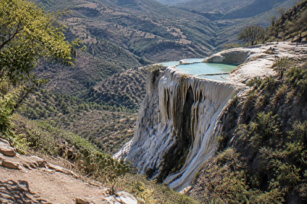 The mineral terraces of Hierve el Agua seen from a mountain trail above the valley
