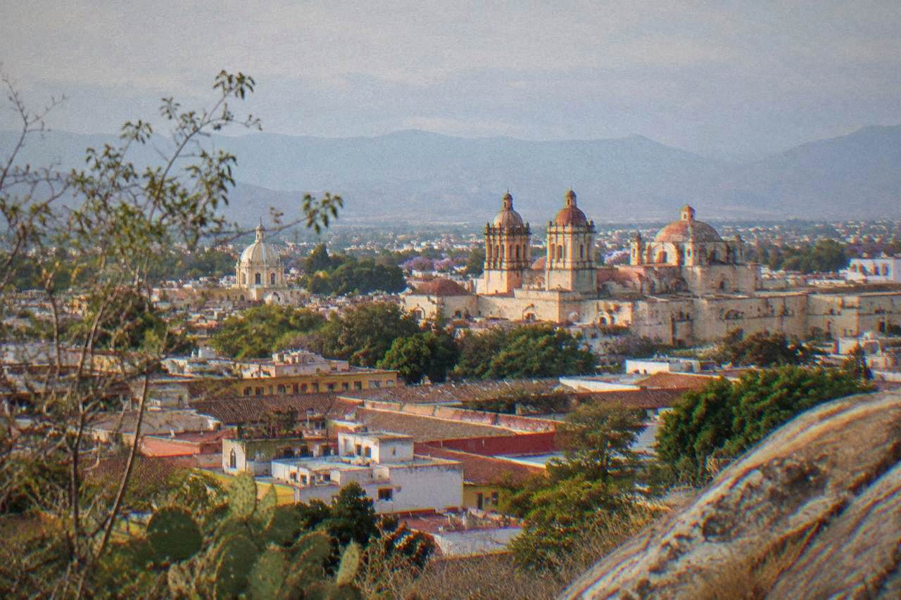 View over the tiled roofs and church domes of Oaxaca City at late afternoon