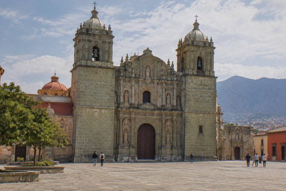 The stone facade of Santo Domingo church in Oaxaca City seen from the plaza in front of it