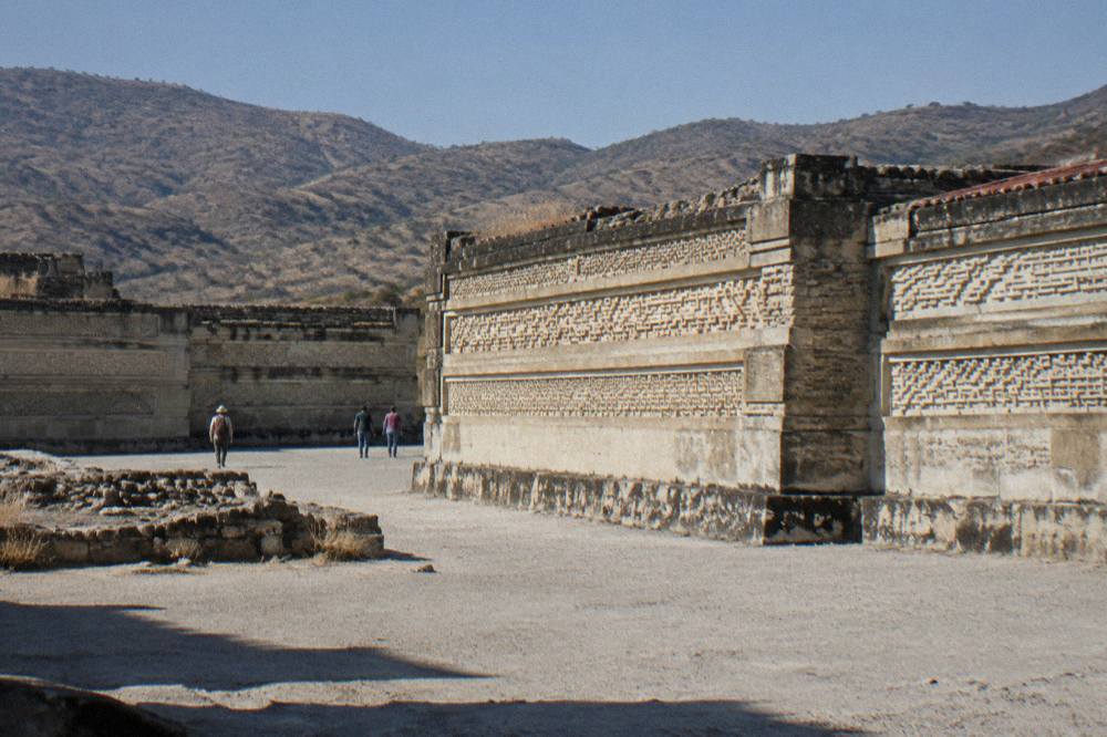 Stone mosaics and adobe walls of the Mitla archaeological zone under a clear sky